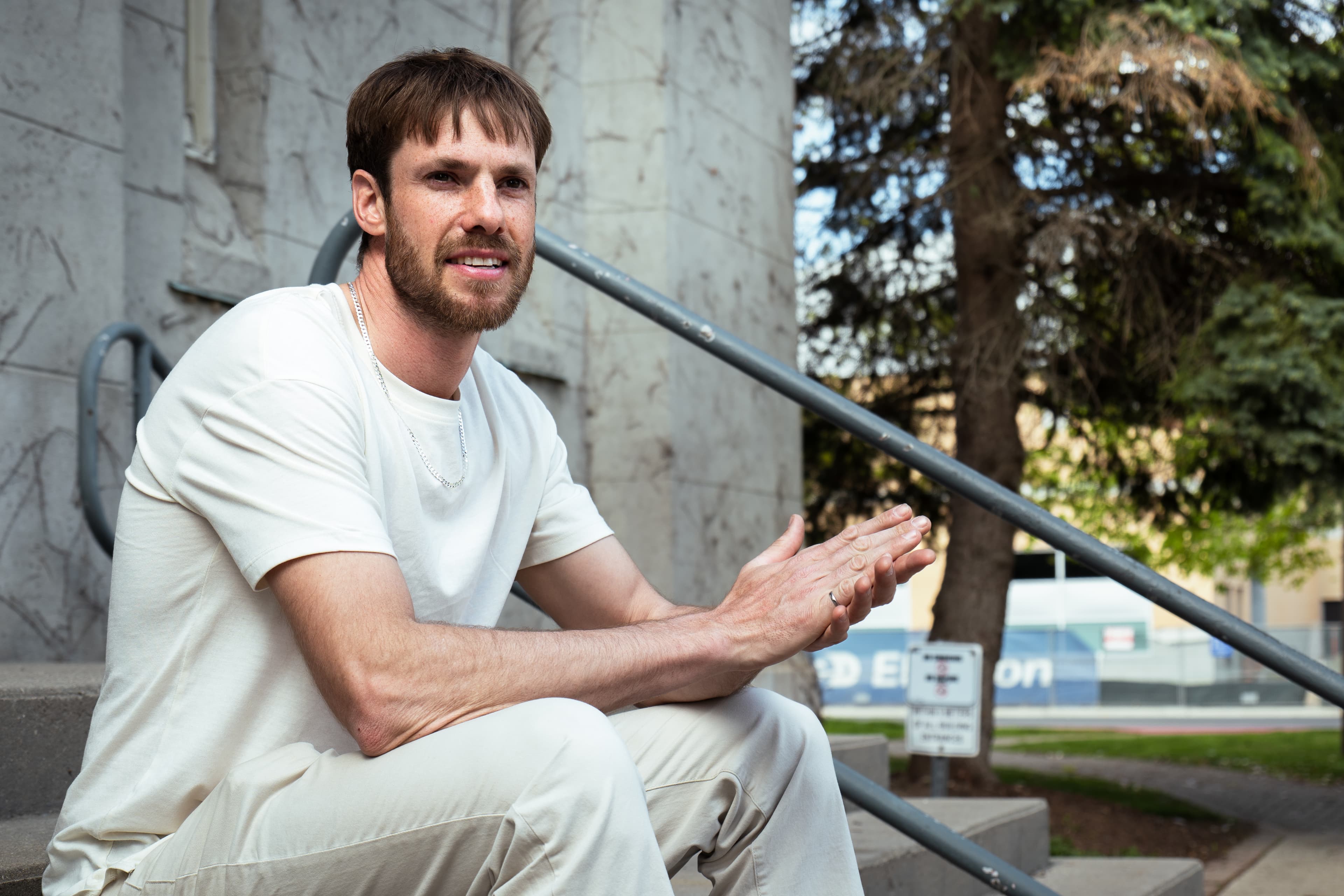 Man sitting on stone steps in a contemplative pose