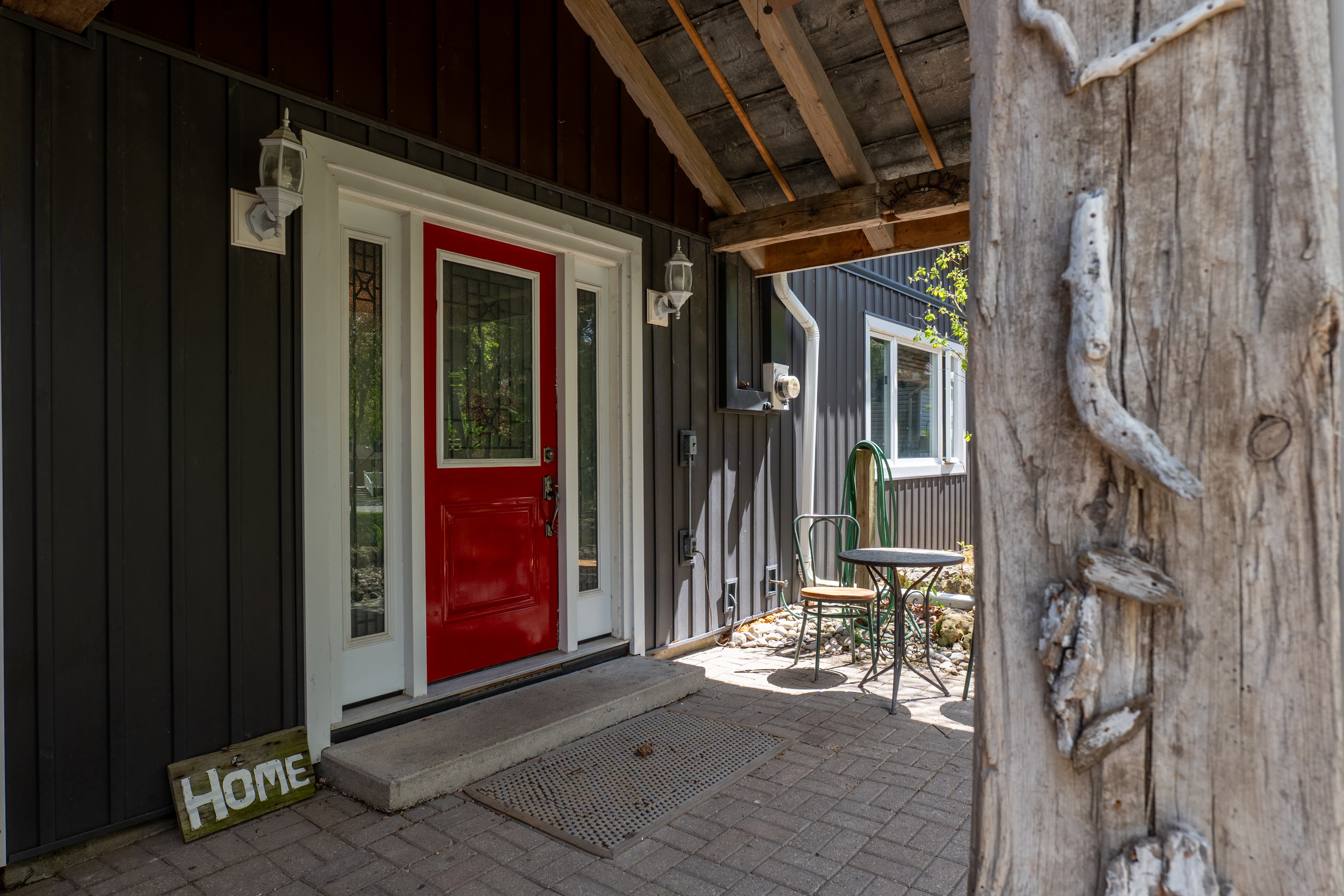 A bright red front door framed by a covered porch entrance