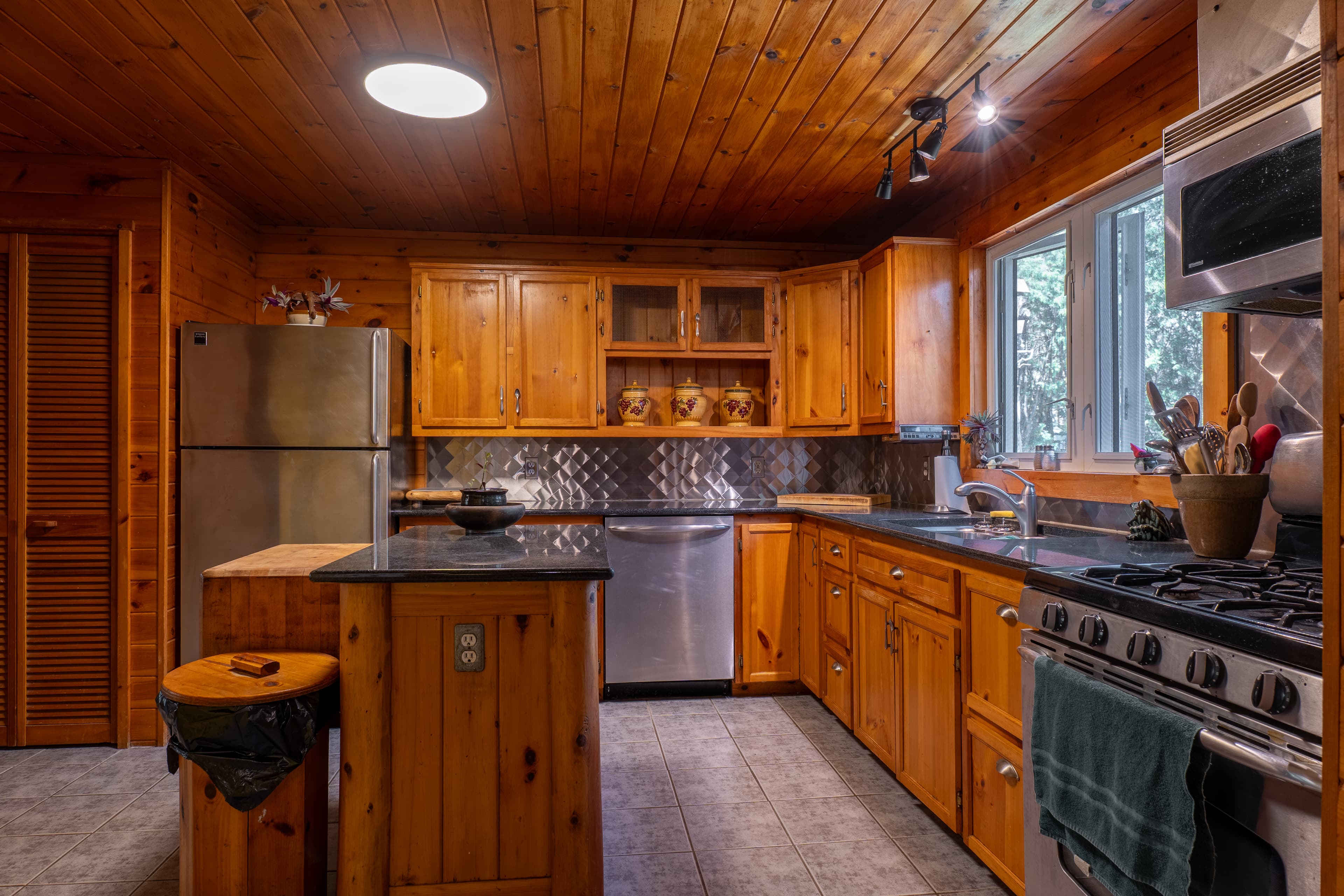 Rustic pine kitchen with warm wood cabinets and gas stove