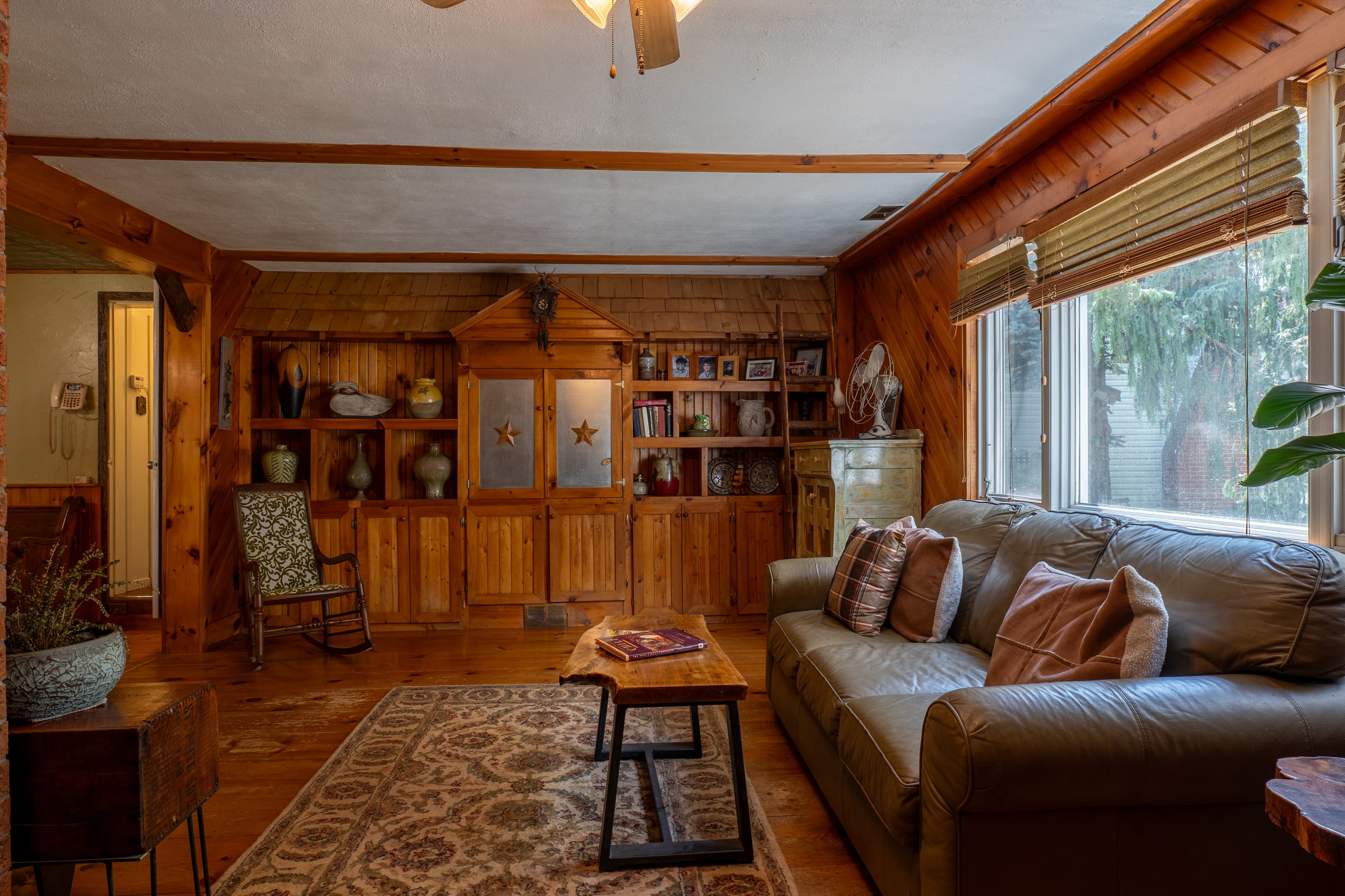 Rustic cabin living room with leather sofa and wood beam ceiling